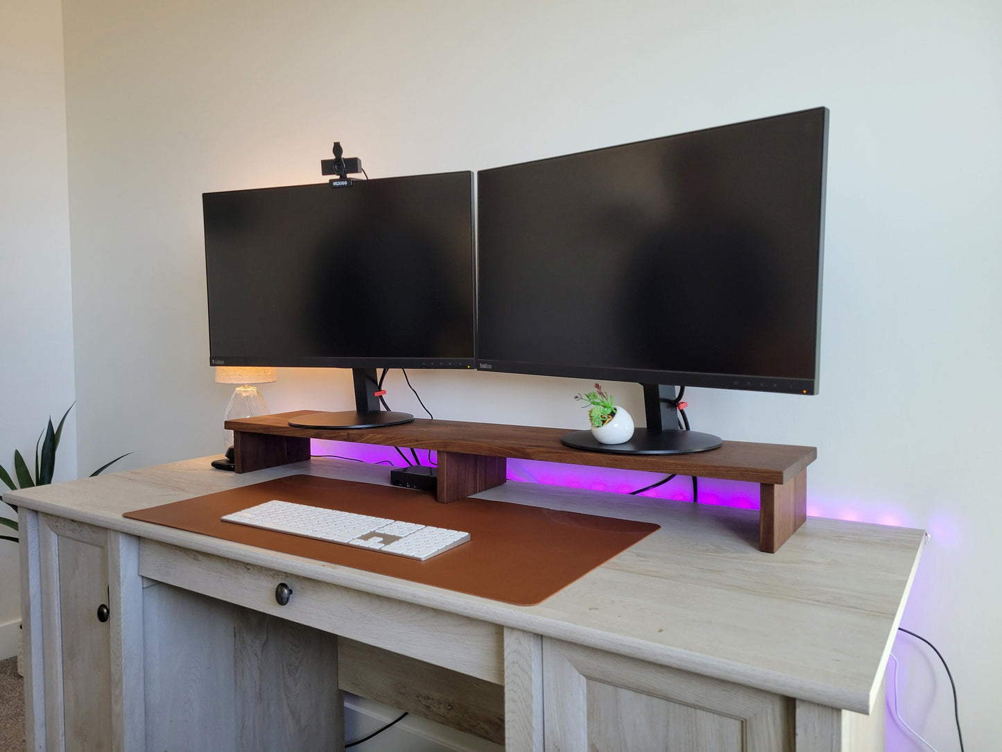 a computer desk with two monitors and a keyboard