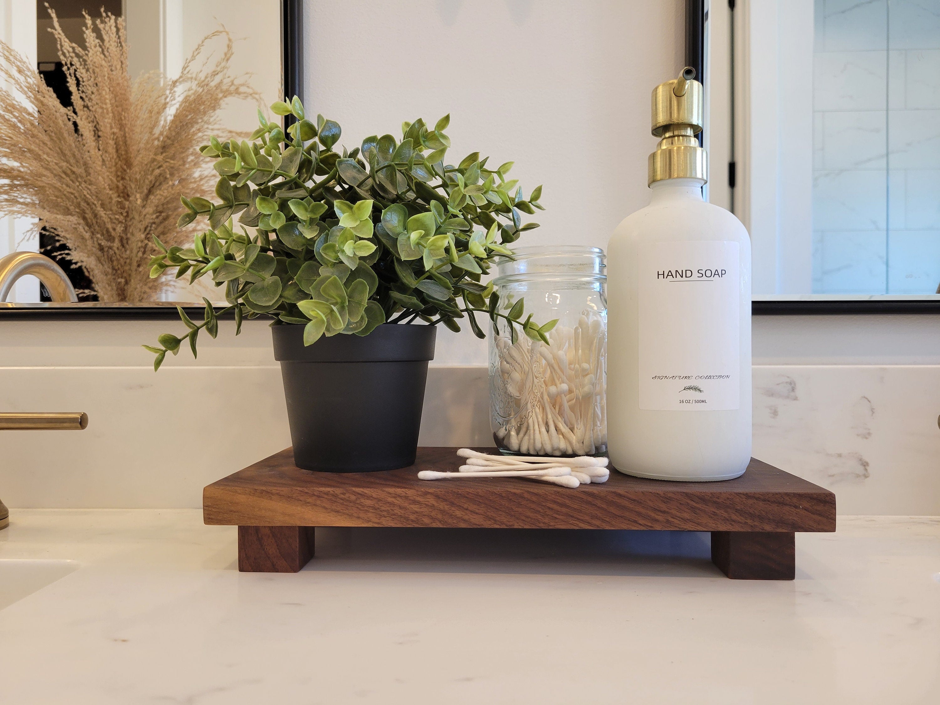 a bathroom counter with a plant and a bottle on it