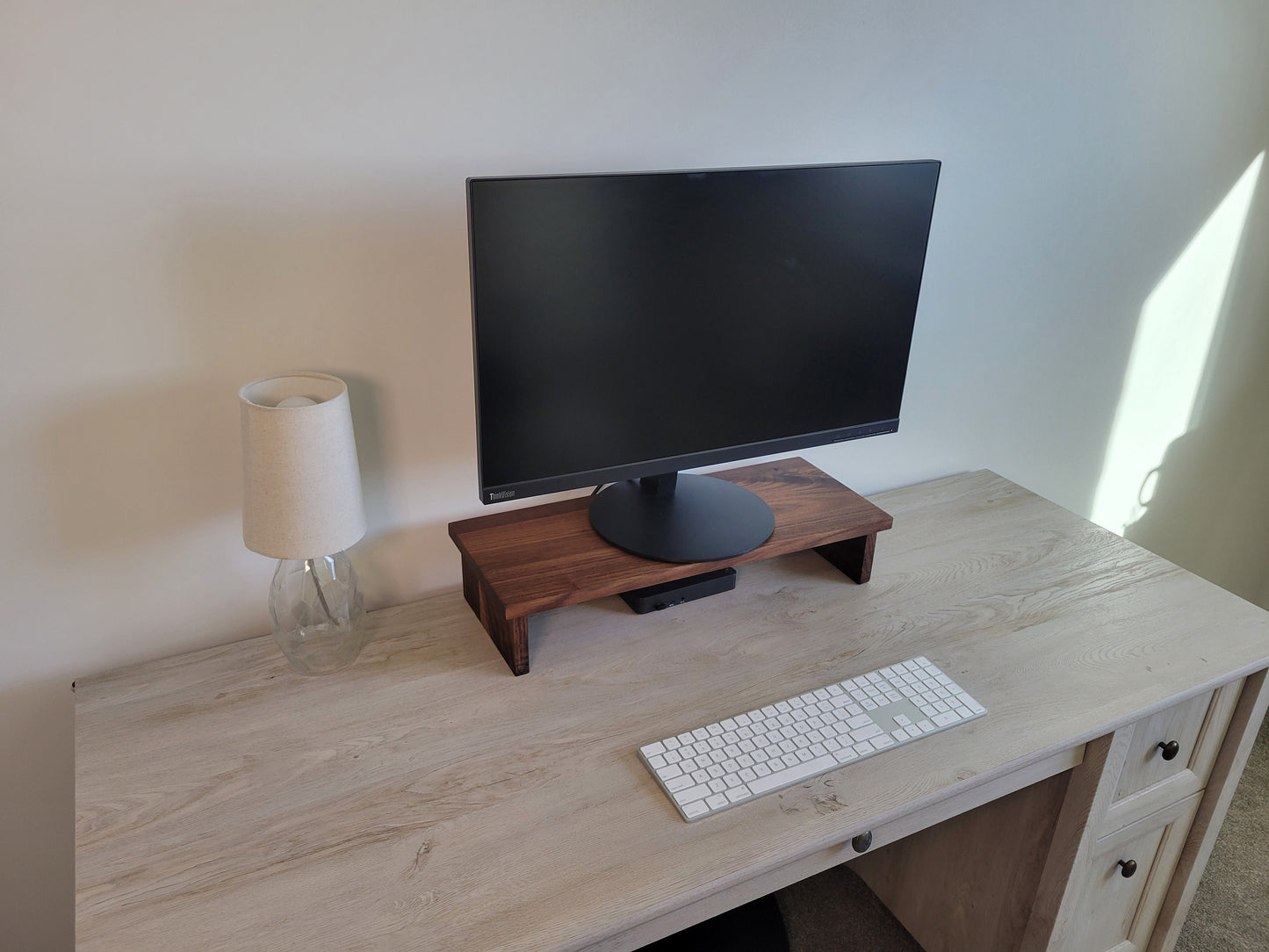 a computer monitor sitting on top of a wooden desk