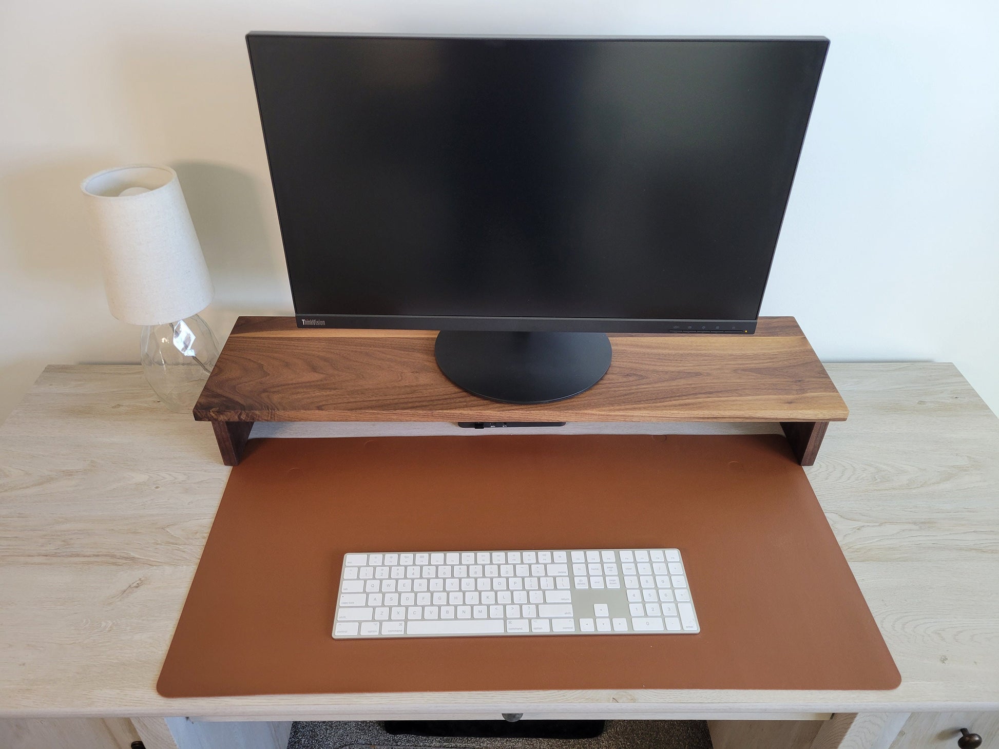 a computer monitor sitting on top of a wooden desk